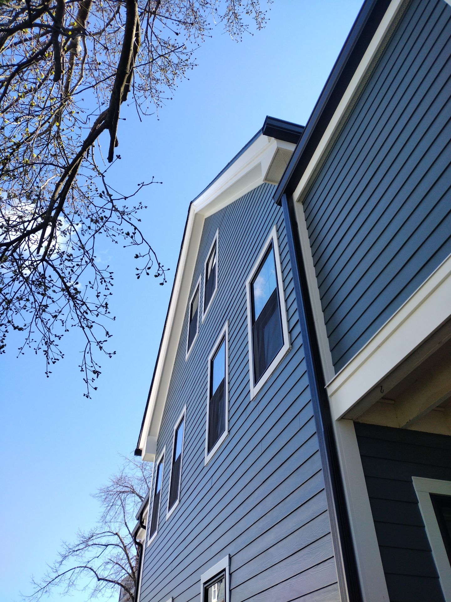 Multi-story home showcasing black window frames with gray siding