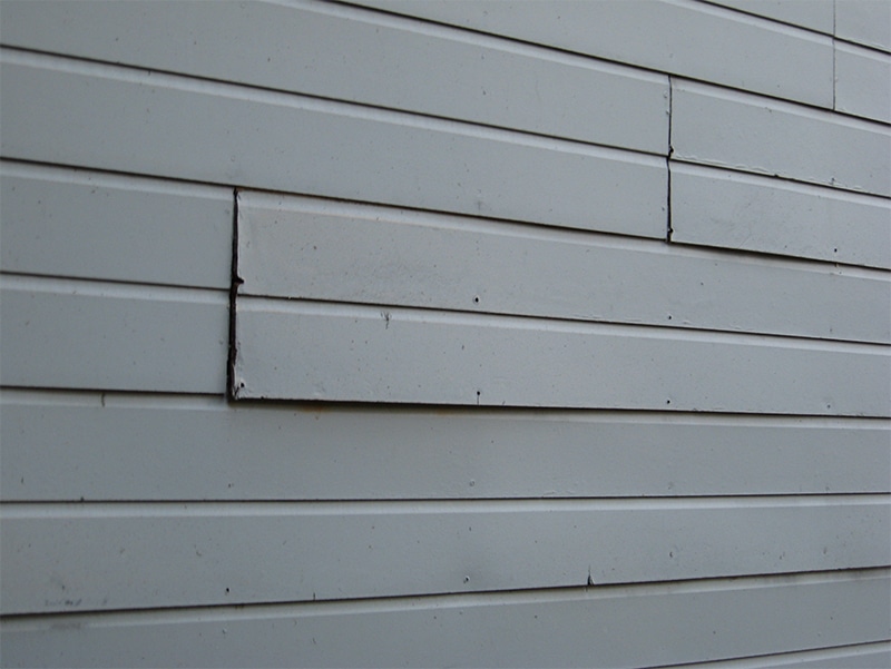 loose and cracked siding panels