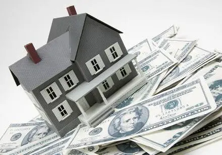 A model house rests on a pile of US twenty-dollar bills, highlighting the importance of being financially savvy when considering home improvements and the cost vs value in real estate investment.