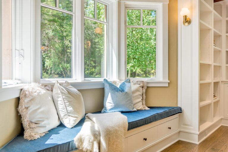 Interior view of energy-efficient replacement windows with cozy seating area in Bedford MA