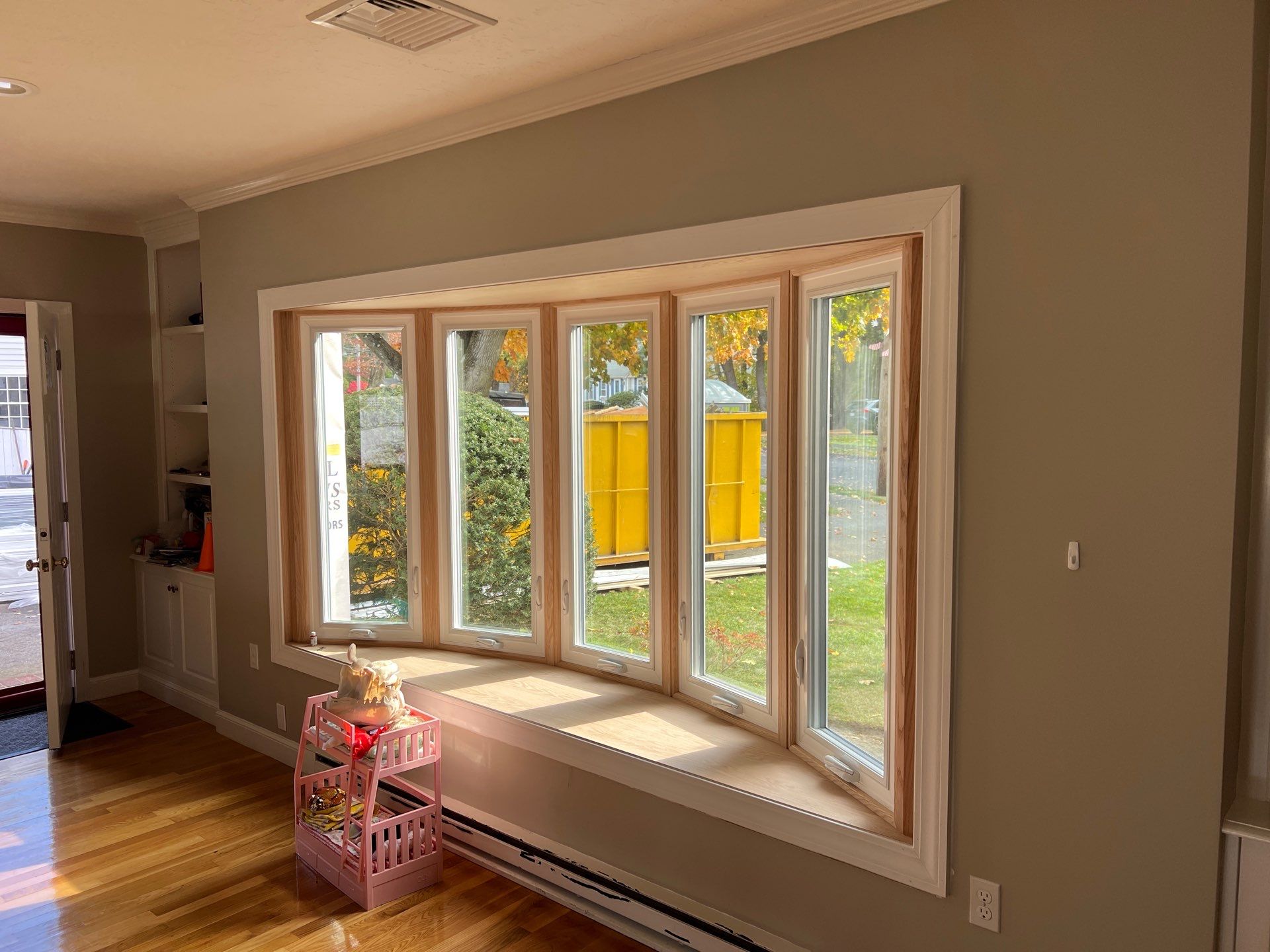 Professional window replacement contractor installs bow windows for natural light in Needham MA, Norfolk County, MetroWest region during summer remodeling