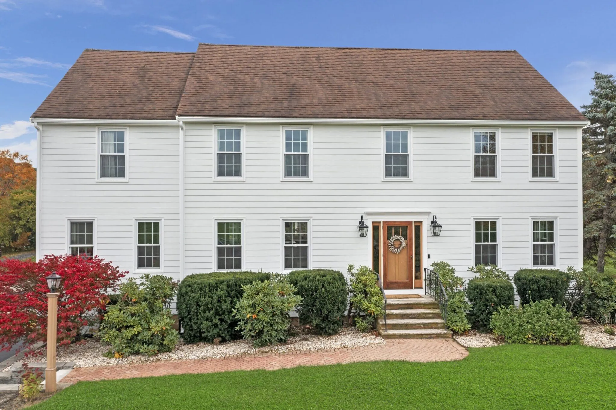 A colonial-style home features freshly installed fiber cement siding that delivers a clean, modern appearance. Fiber cement siding is often chosen as one of the best high-roi exterior upgrades due to its durability and low maintenance requirements.