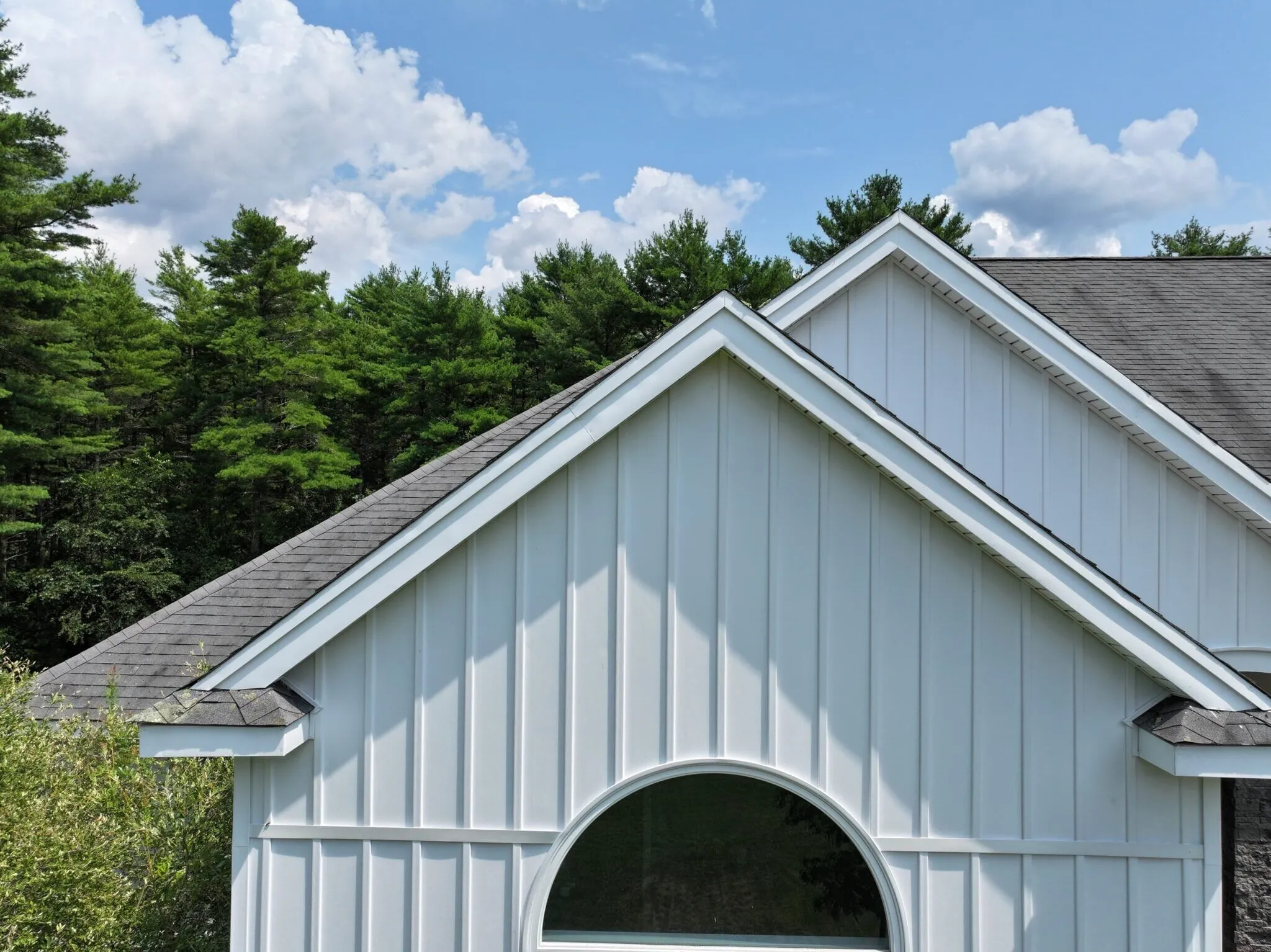 Clean white board and batten siding accents complement the architectural design of this home. Modern siding installations are considered valuable high-roi exterior upgrades because they enhance both appearance and weather resistance.
