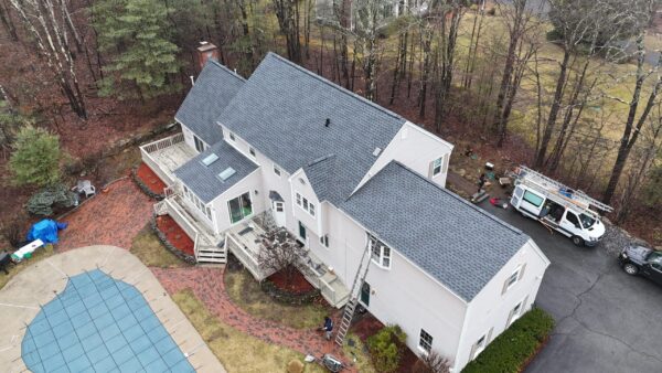 Aerial view of a newly installed roofing system designed to withstand harsh New England weather conditions. Homeowners researching how long does a roof last in Massachusetts often invest in durable roofing materials that help protect against storms, ice dams, and seasonal temperature changes.